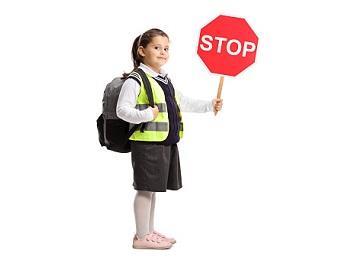 dziewczynka w kamizelce odblaskowej ze znakiem stop